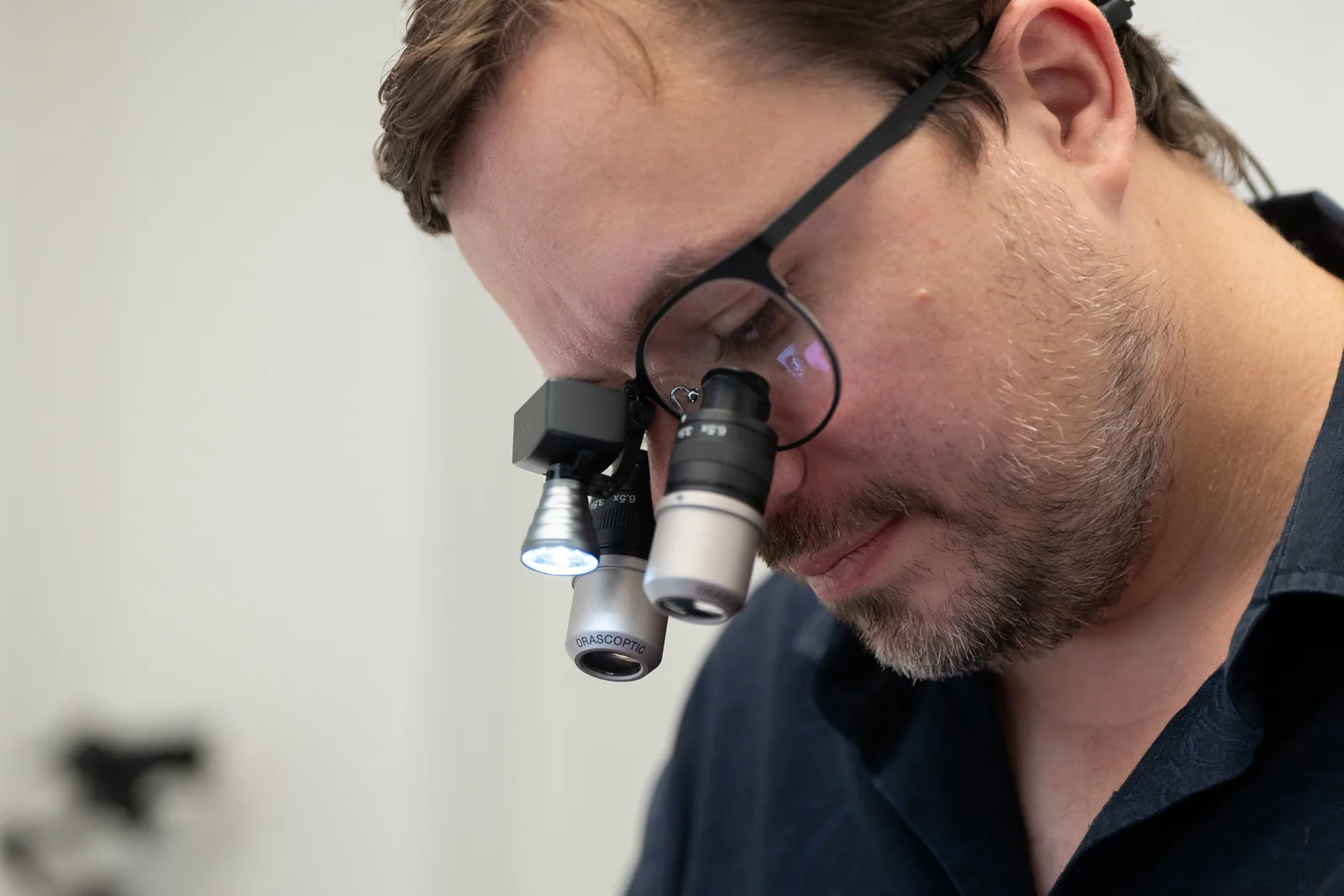 Dr. med. dent. M.Sc. Sandro Strößner mit Lupenbrille